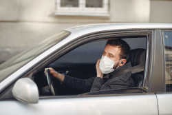 Man driving while wearing a mask