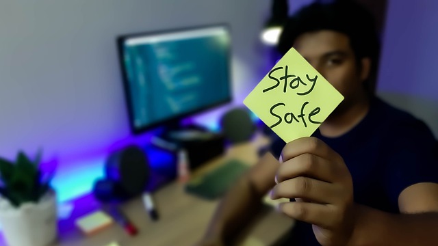 Man holding a stay safe post it note
